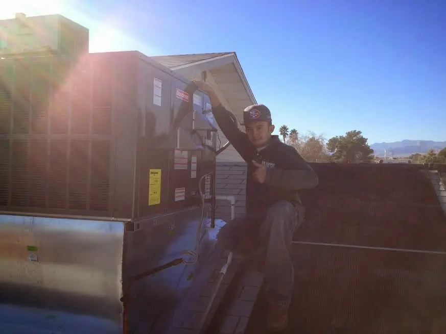 HVAC technician performing AC Tune-Up on a rooftop unit in New Square